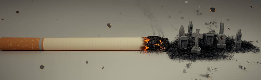 Nikotinsucht bekämpfen - glühende Zigarette auf dem Tisch 