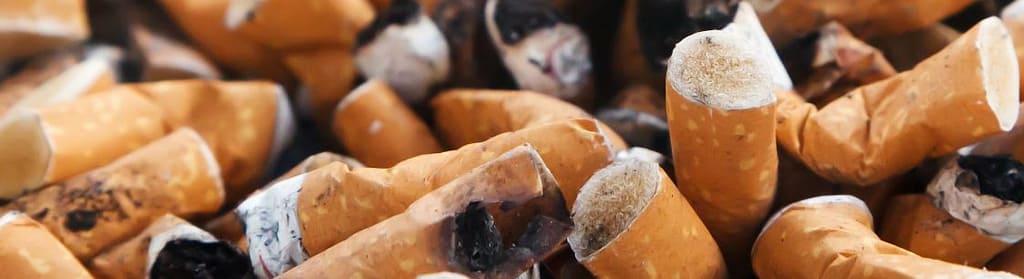 Rauchstopp und Gesundheit - Zigarettenkippen in einem Aschenbecher